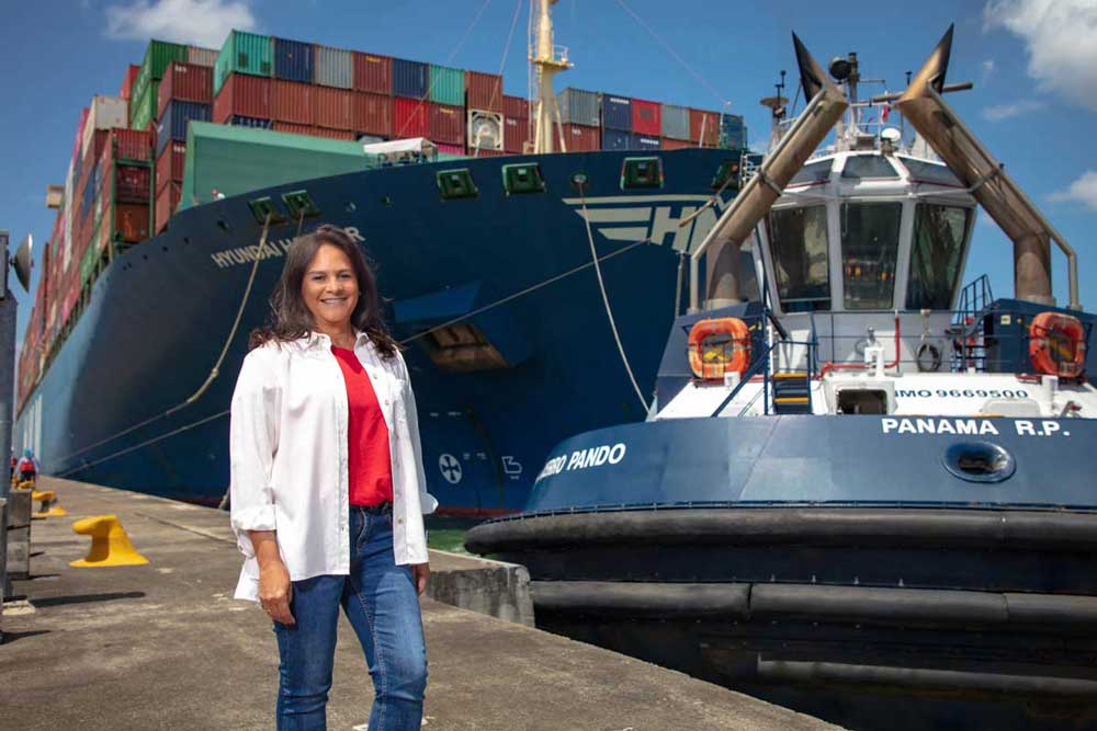 Ilya Espino de Marotta, Administrator of the Panama Canal Authority, in front of a tugboat and a container ship
