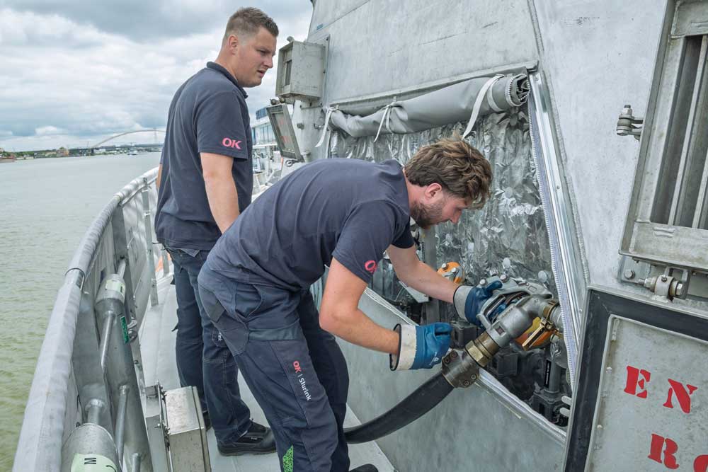 Two men are refuelling a ship