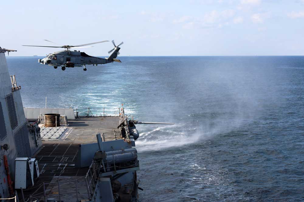A helicopter lands on a US Navy ship