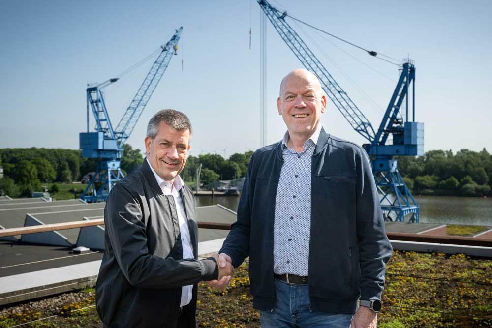André Walter (left) and Bernd Eikens on the grounds of the Meyer shipyard, with two cranes in the background