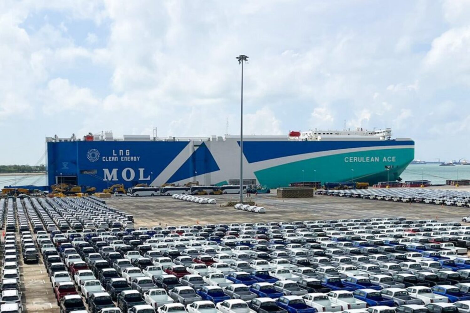 An MOL car carrier in the port. New cars are in the foreground.